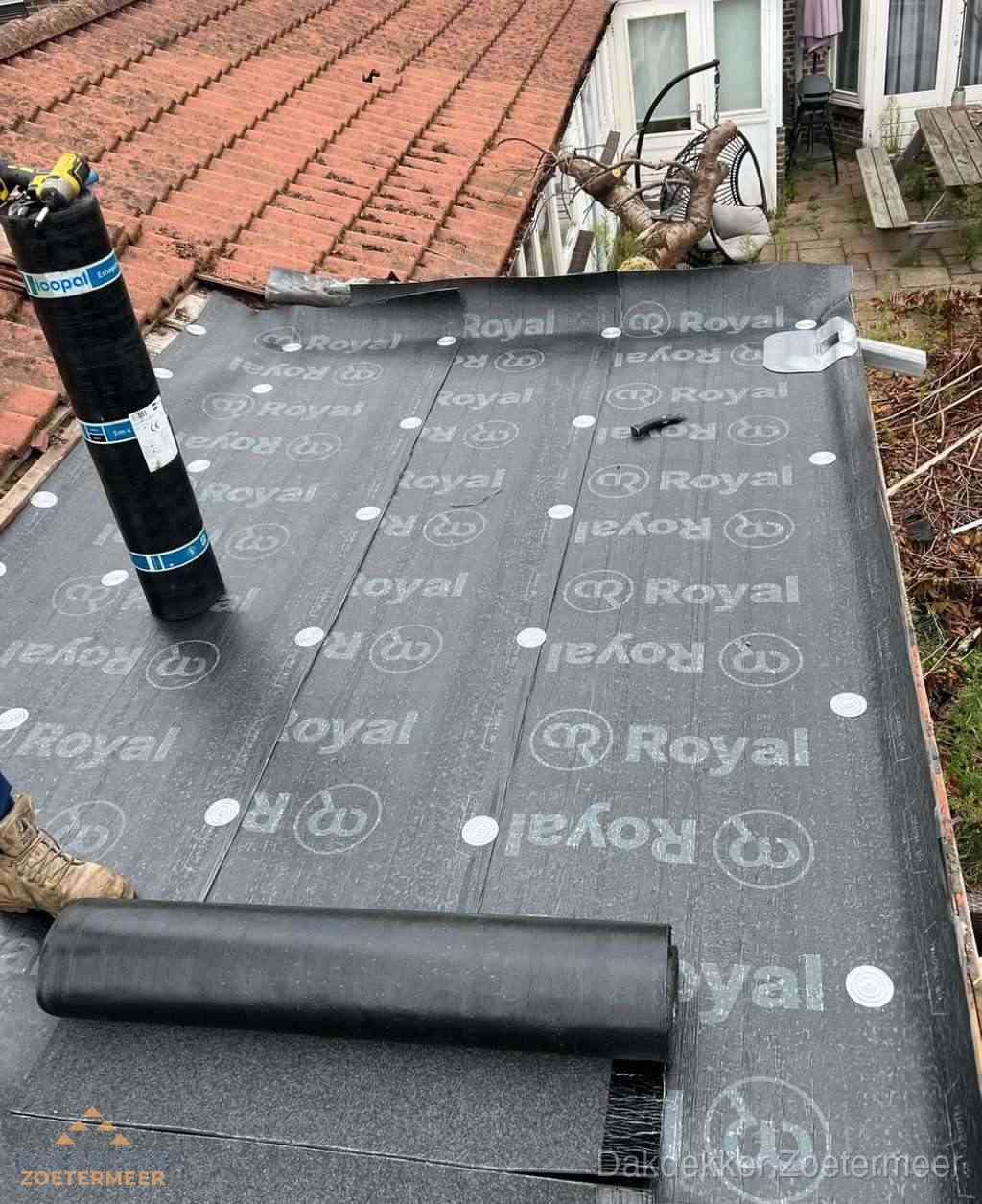 Plat dak met nieuwe bitumen dakbedekking en brandgereedschap in Zoetermeer