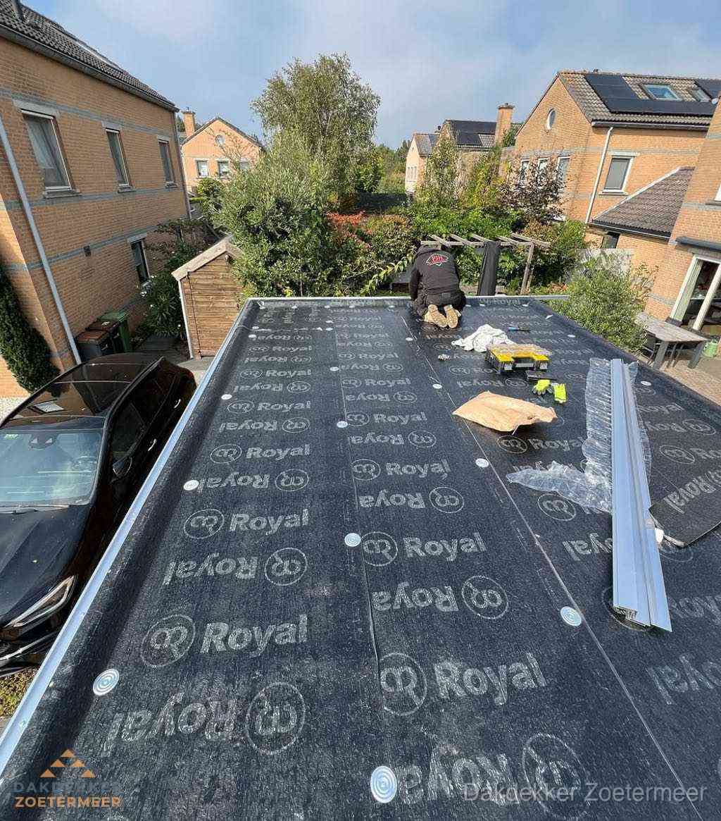 Dakdekker aan het werk op plat dak renovatie in Zoetermeer