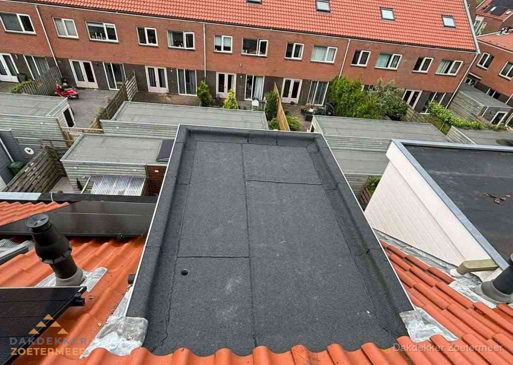 Plat dak met bitumen bedekking naast dakkapel in Zoetermeer