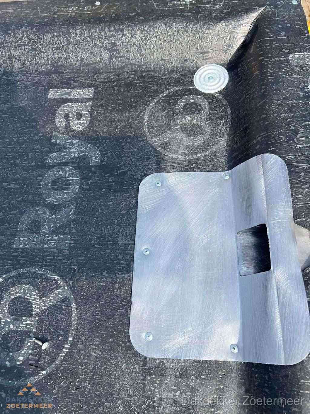 Dakdoorvoer met metalen afvoerplaat op bitumen dak in Zoetermeer