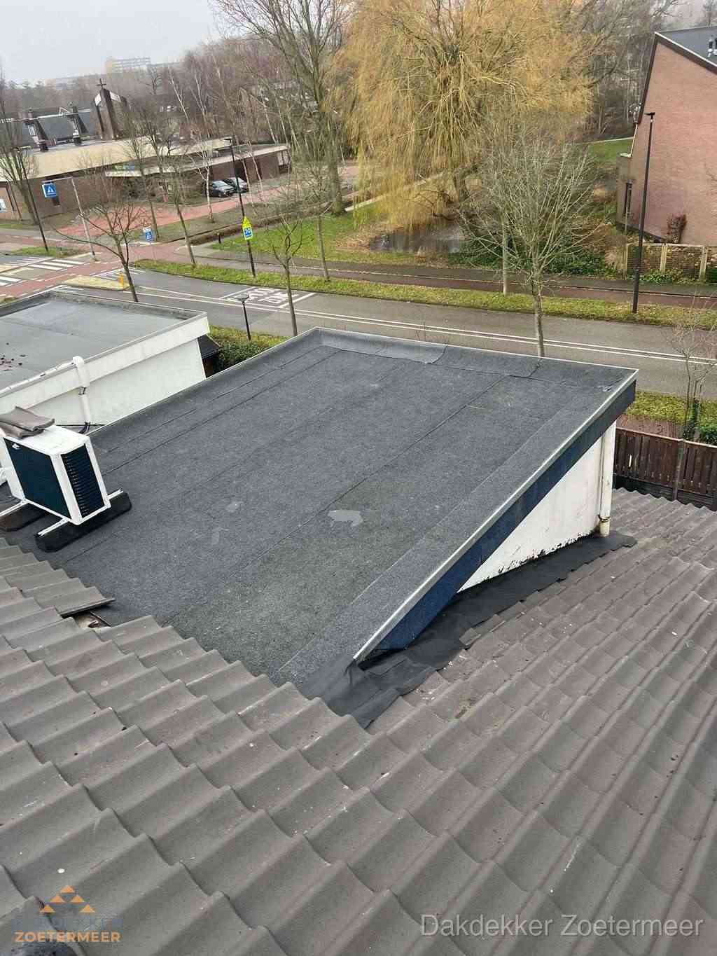 Plat dak met bitumen dakbedekking naast schuin pannendak in Zoetermeer
