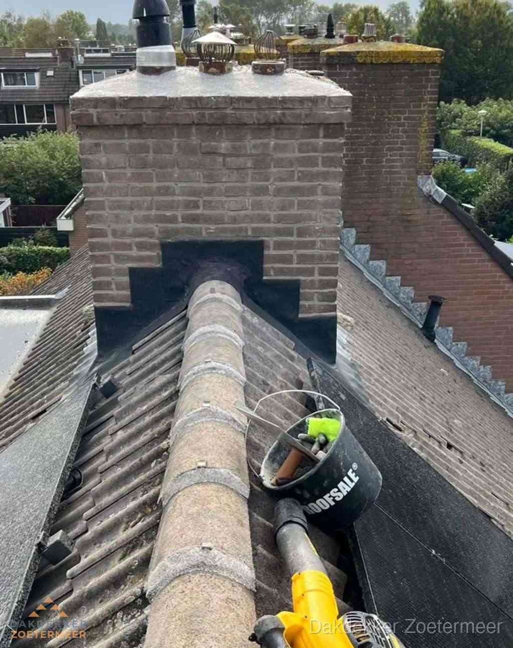 Dakdekker repareert bitumen dakleer bij dakdoorvoer in Zoetermeer